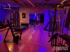 a room with purple lighting and wooden floors