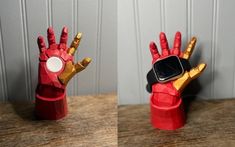 two red and gold hand shaped objects sitting on top of a wooden table next to each other