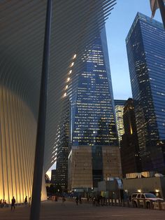 the city skyline is lit up at night, with tall buildings in the foreground