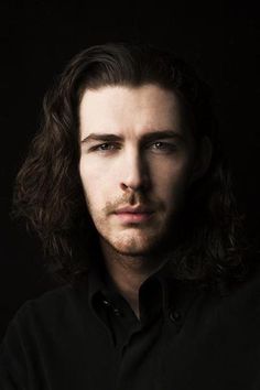 a black and white photo of a man with long hair