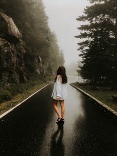 a woman walking down the road in the rain