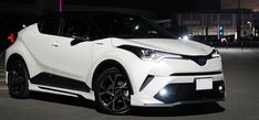 a white toyota suv parked in a parking lot at night