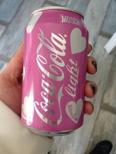 a person holding up a pink soda can with hearts on the front and bottom half