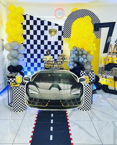 a car is parked in the middle of a room decorated with balloons and streamers