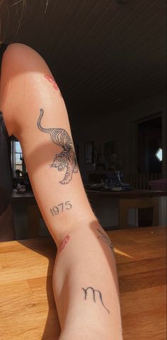 a woman with tattoos on her arm sitting at a table