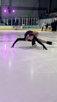 a woman is skating on an ice rink with her legs spread out and feet bent