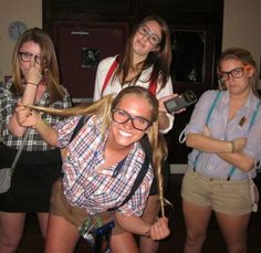 four girls are posing for the camera with one girl holding her hair in front of her face