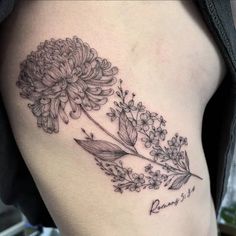 a black and white photo of a flower on the side of a woman's thigh