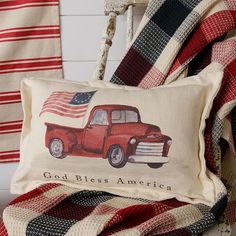 a red truck with an american flag on it is sitting next to a plaid blanket