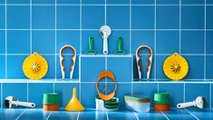 several different types of kitchen utensils on a blue tiled wall