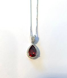 "Garnet Crystal Necklace in Sterling Silver Pear Design with Cubic Zirconia Halo -925 Sterling Silver Setting -925 Sterling Silver Box Chain -14\", 16\", 18\", 20\", 22\" Chain Length - 21length and 7mm width - Cubic Zirconia Stone Accents 🎁Packaging: This item comes gently packaged in a fabric pouch housed inside of a silver foil linen box with a silver bow. It is ready to present as a gift to someone special or to keep as a gift to yourself! 🚛 Shipping: Shipped from USA. Shipping is free wit January Birthstone Necklace, Oversized Hoop Earrings, Pear Shaped Pendant, Fabric Pouch, Garnet Crystal, Garnet Necklace, Garnet Jewelry, Silver Bow, January Birthstone