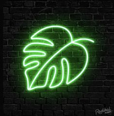 a neon sign that is on the side of a brick wall with a palm tree