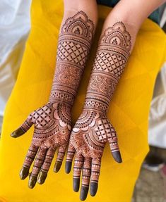 two hands with henna tattoos on them