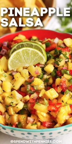 pineapple salsa in a bowl with lime wedges and cilantro on the side