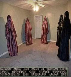 three people in robes are standing in the middle of a room with a ceiling fan