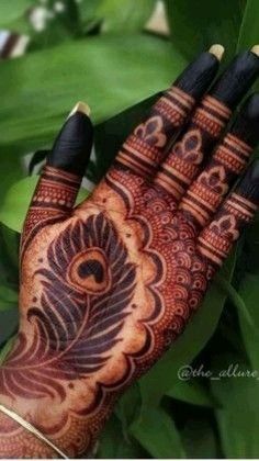 the hand is decorated with henna and peacocks on it's palmes