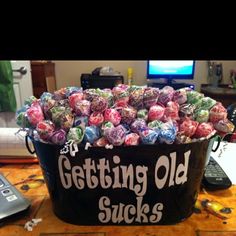 a large bucket filled with candy sitting on top of a table next to a computer