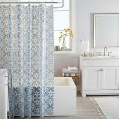 a bathroom with a shower, sink and bathtub next to a window in it