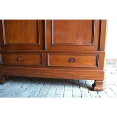 a large wooden dresser sitting on top of a brick floor