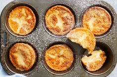 baked desserts in muffin tins with powdered sugar on top and one being eaten