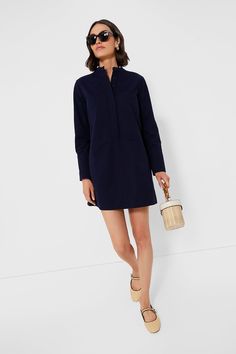 Elevate your capsule wardrobe with the Navy Twill Denim Wellington Dress. This mini is constructed from a structured organic cotton, featuring a crisp stand collar, front button placket with chest patch pockets, and long sleeves with long cuffs offering polished and elegant look. Exquisitely chic, we are pairing this number with everything from sneakers to sandals. Stand collar Long sleeves with long button cuffs Concealed front button placket Center back pleat Front patch pockets Side seam pock Cotton Shirt Dress With Buttoned Pockets For Fall, Fall Cotton Shirt Dress With Buttoned Pockets, Spring Workwear Dresses With Patch Pockets, Navy Shirt Dress For Spring Workwear, Fall Workwear Cotton Shirt Dress, Cotton Shirt Dress For Fall Workwear, Fall Cotton Shirt Dress For Work, Modern Long Sleeve Shirt Dress For Spring, Mini Shirt Dress With Button Cuffs For Workwear