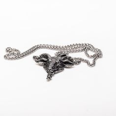 Stunningly intricate and made from durable alloy steel, the Goat Head Necklace boasts a large 2.5 by 2.3 inch pendant, complemented by a sturdy 25 inch double link chain. Premium craftsmanship exudes from every inch of this piece. Oxidized Metal Pendant Chain Necklace, Metal Chain Necklace With Oxidized Finish Pendant, Engraved Metal Pendant Chain Necklace, Silver Metal Chain Necklace With Wheat Chain, Silver Metal Jewelry With Wheat Chain, Silver Jewelry With Wheat Chain, Goat Head, Dark Elegance, Head Necklace