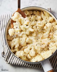 a pot filled with macaroni and cheese on top of a table