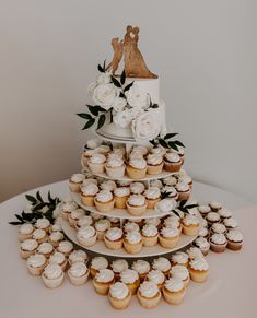 a wedding cake and cupcakes on a table