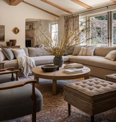 a living room with couches, chairs and a coffee table in front of a window