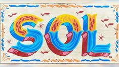 the word sold is painted on wood with colorful designs and colors, including red, yellow, blue, and orange