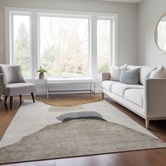 a living room with white couches and large windows in the corner, along with two chairs