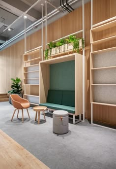 an office with wooden shelves and green plants on the wall, along with two chairs