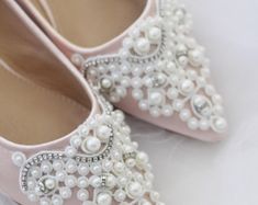 a pair of pink shoes with pearls on them