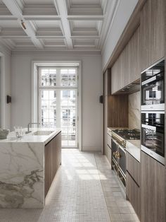 a large kitchen with marble counter tops and wooden cabinets, along with an open window