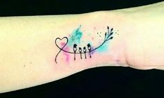 a small tattoo on the wrist that has arrows and hearts painted on it with watercolors