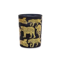 a black cup with gold leopards and elephants on the inside, in front of a white background