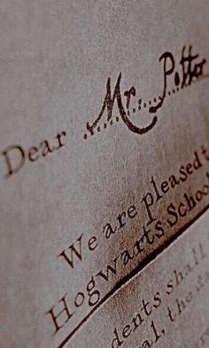 the hogwarts school's logo is etched onto some old paper with writing on it