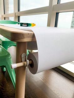 a close up of a roll of paper on top of a wooden table near a window