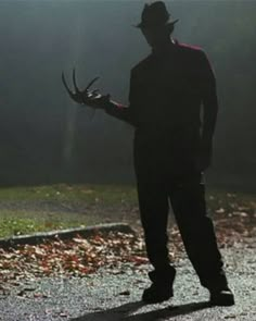 a man standing in the middle of a road holding a deer's antlers