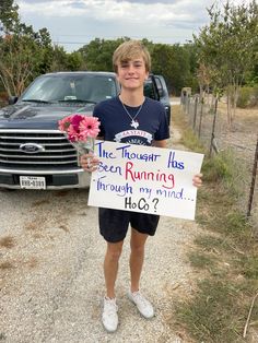 a young man holding a sign with flowers in his hand and a truck behind him that reads, the thought has been running through through through through through through through through through through through through through through through through through through through through through through through through through through through through through through through through