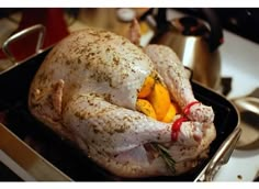 a roasted turkey in a roasting pan with spices on it's side and the rest of its body visible