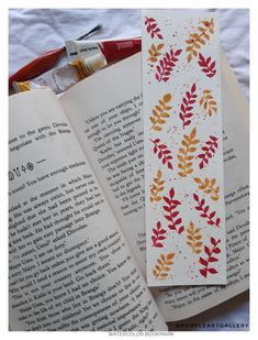 an open book sitting on top of a table next to scissors and paintbrushes