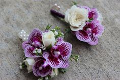 two purple and white flowers are placed on the ground next to each other with pearls