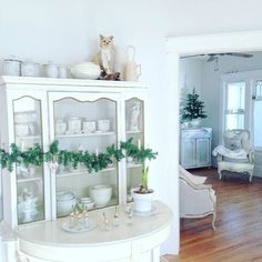 a white china cabinet with christmas decorations on top