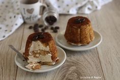 two desserts sitting on top of white plates next to a coffee cup and saucer