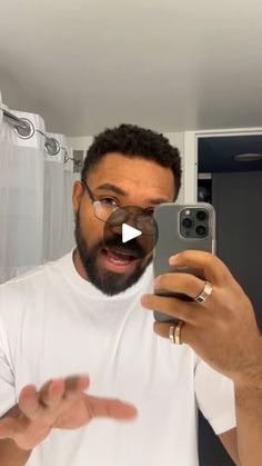 a man is taking a selfie in the mirror with his cell phone while wearing glasses