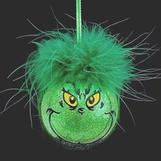 an ornament with green hair and yellow eyes on a black background is shown