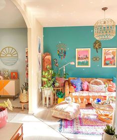 a living room filled with lots of furniture next to a wall covered in pictures and plants