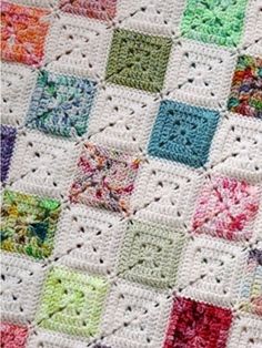 a crocheted blanket with many different colored squares