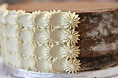 a chocolate cake with white frosting and flowers on top